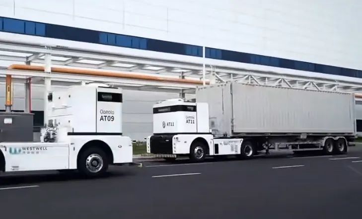 Autonomous electric trucks operate in an industrial facility, showcasing intelligent logistics transportation and automated vehicle technology.