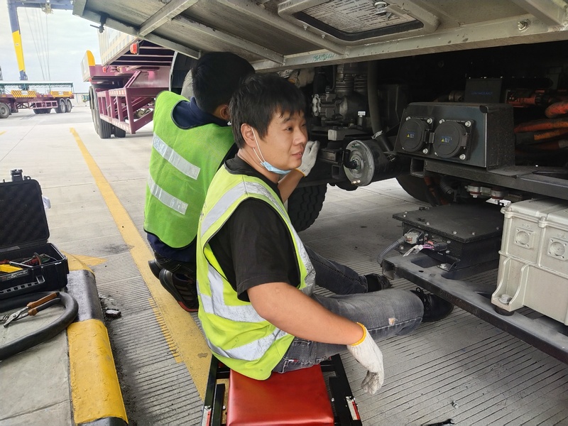 Technicians inspect and maintain an autonomous vehicle's mechanical components during a field service operation.