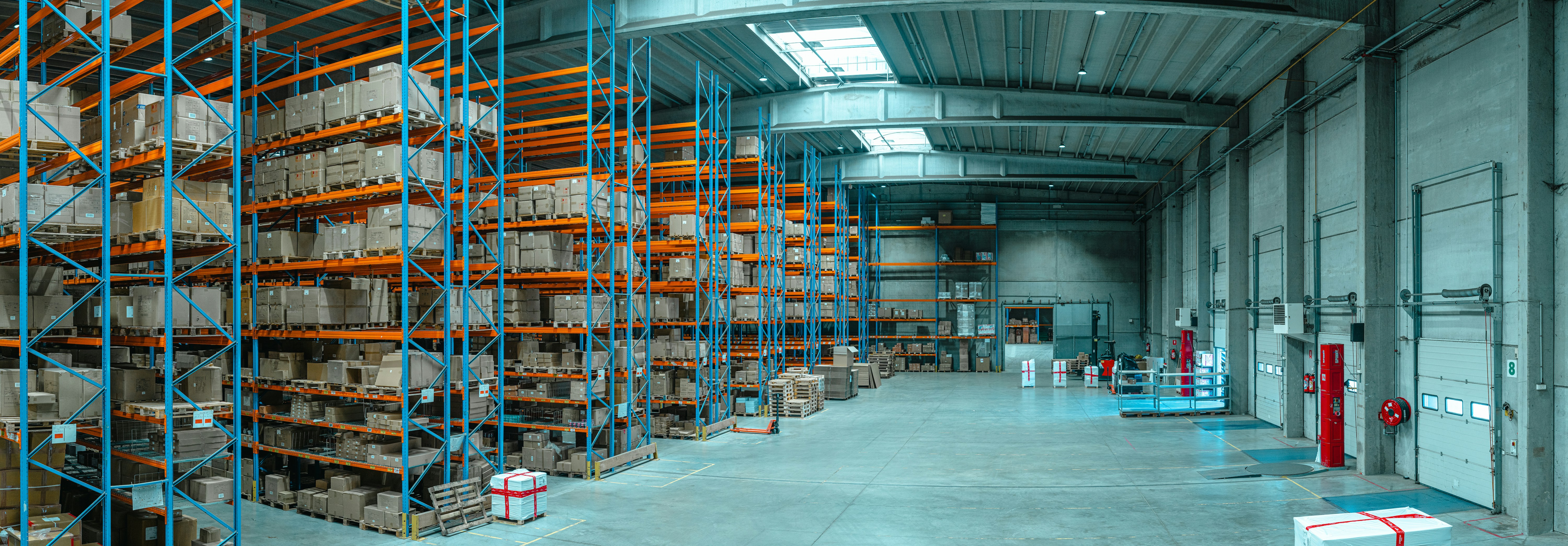 Interior of a modern warehouse showing vertically stacked cargo boxes near the unloading dock area, designed for high-efficiency logistics operations.