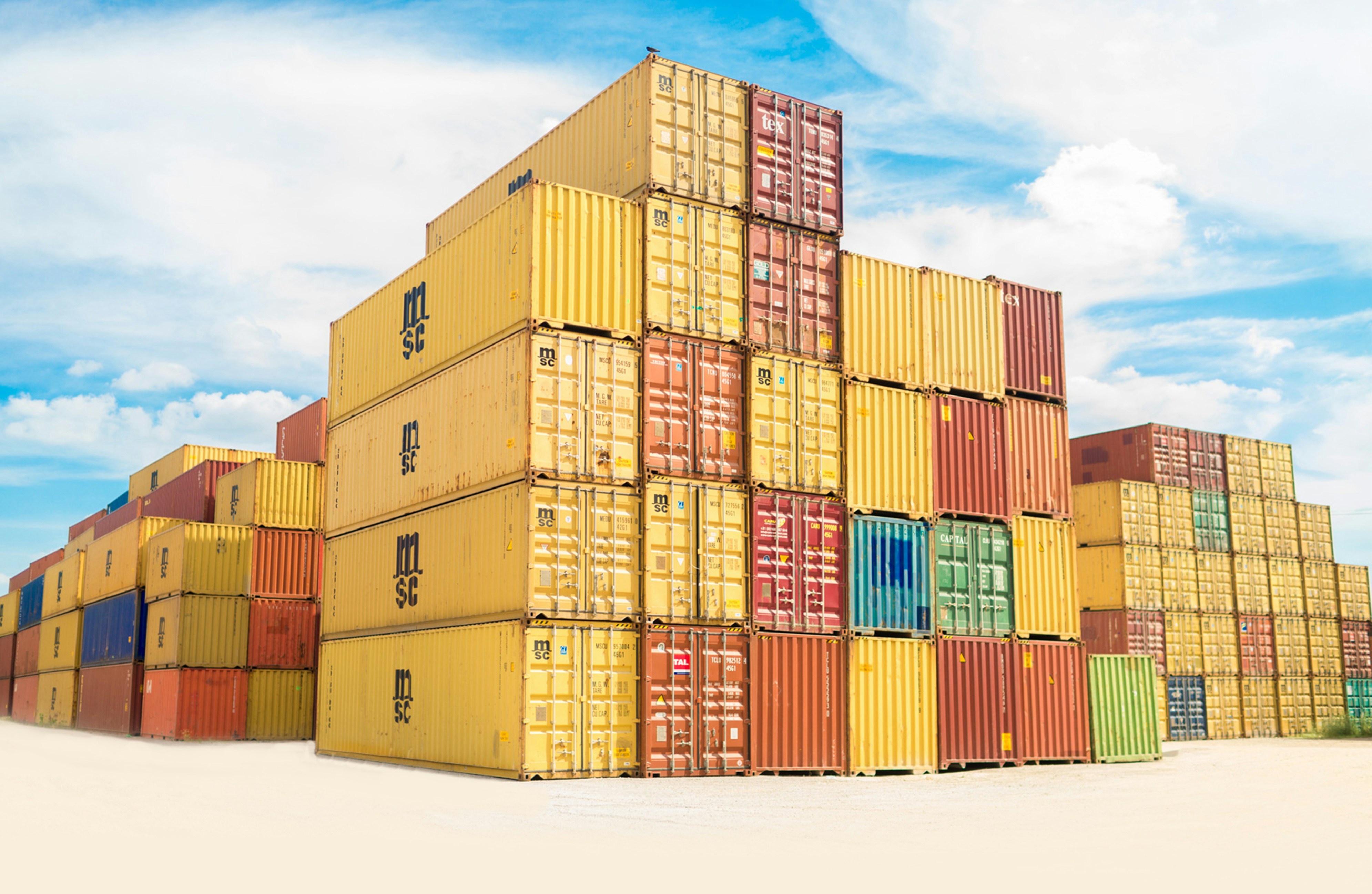 Container yard with stacked containers of various colors and sizes, illustrating active cargo storage and port operations.
