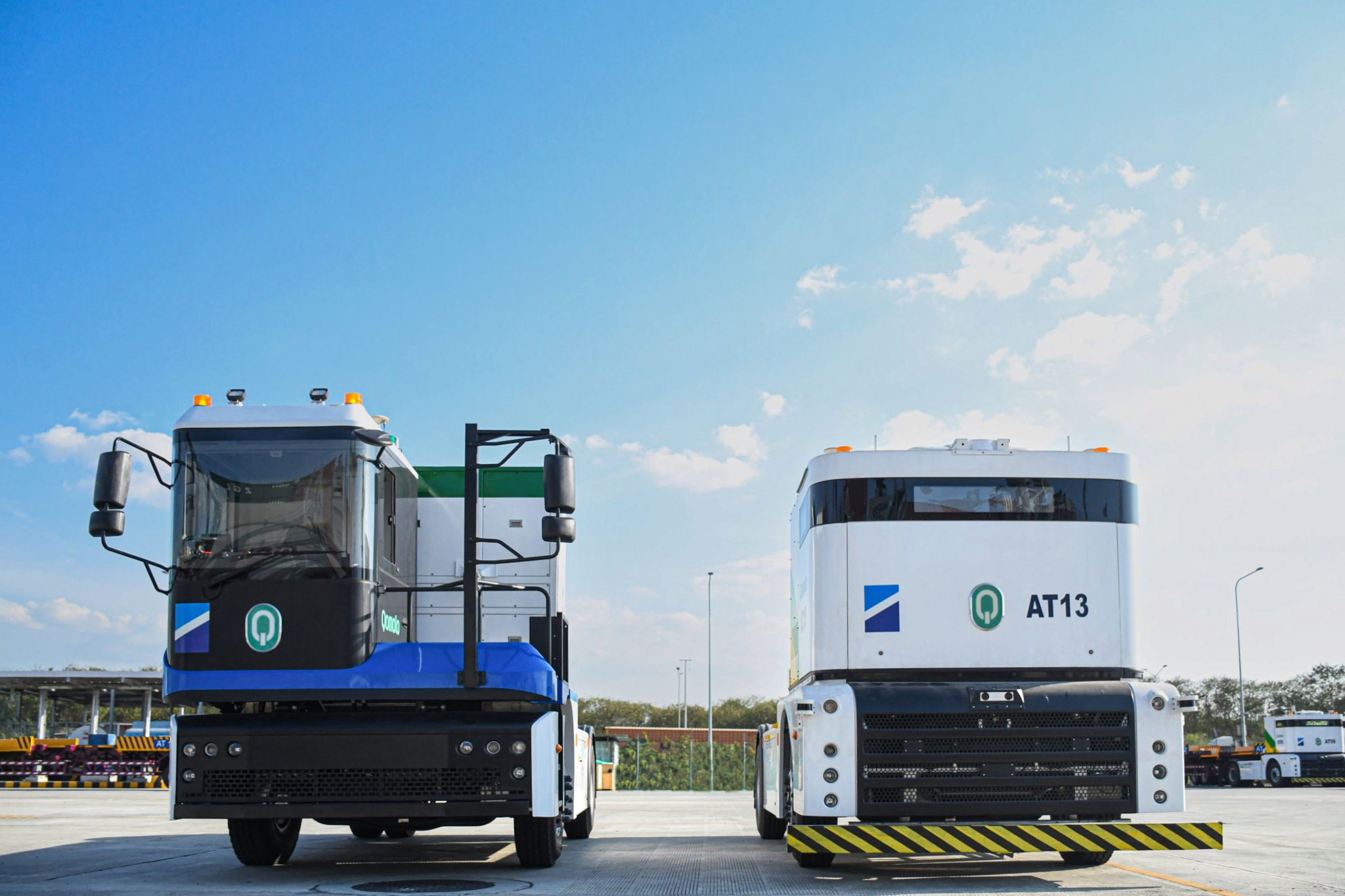 Westwell E-Truck and Q-Truck operating together in Laem Chabang Port, demonstrating coordinated manned and unmanned vehicle operations for efficient logistics.
