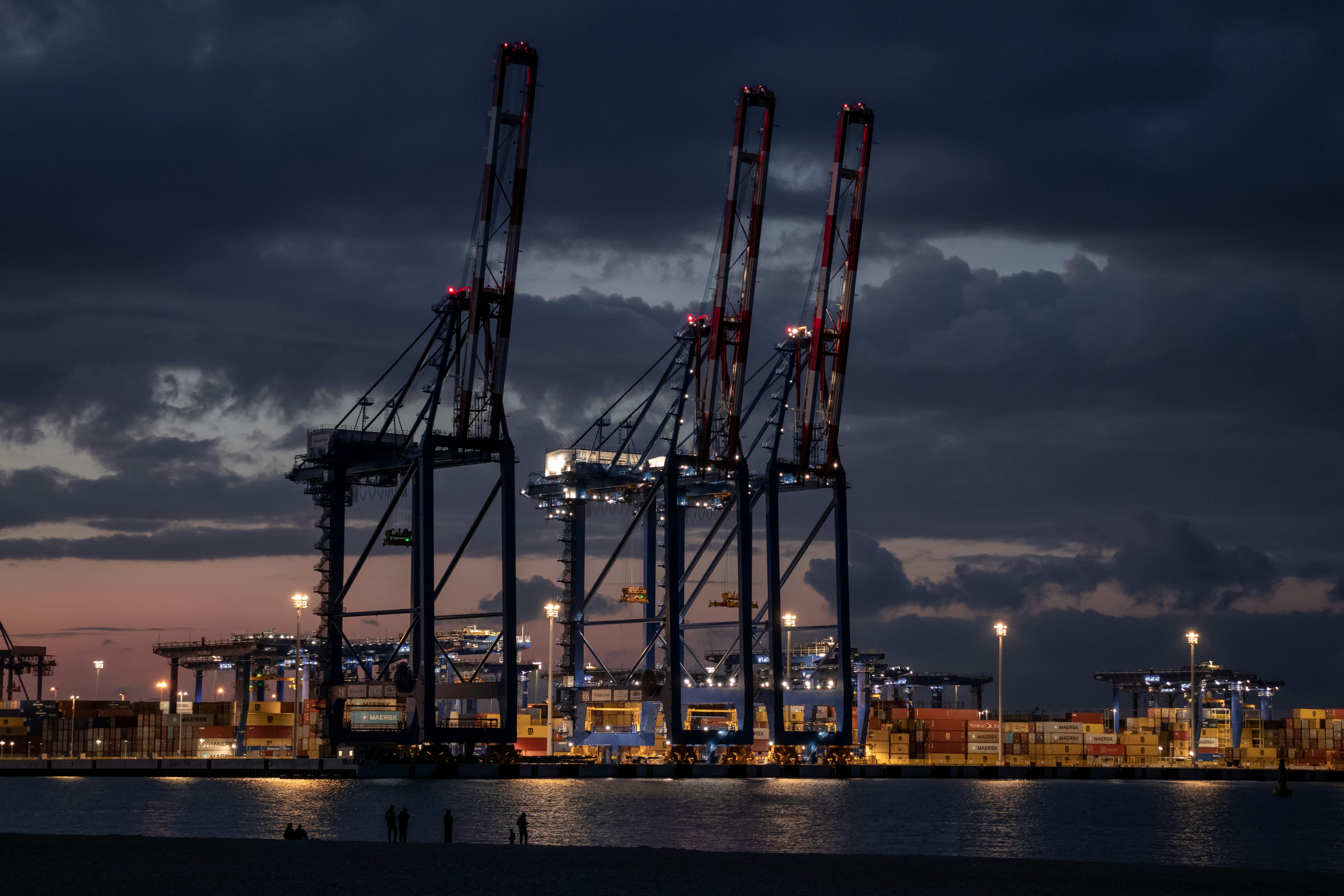 Night view of container portal cranes operating at a seaport in Poland, highlighting modern port operations and container handling infrastructure