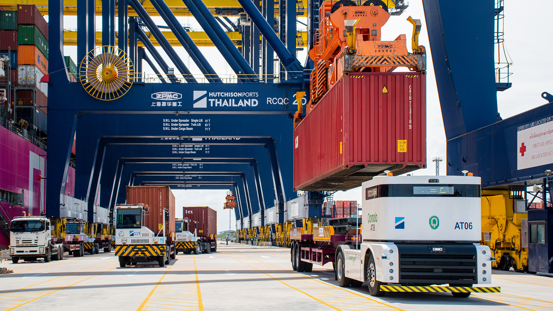 Westwell Q Truck fully autonomous terminal tractors operating under quay cranes at Laem Chabang Port, Thailand, demonstrating automated container handling and smart port logistics.