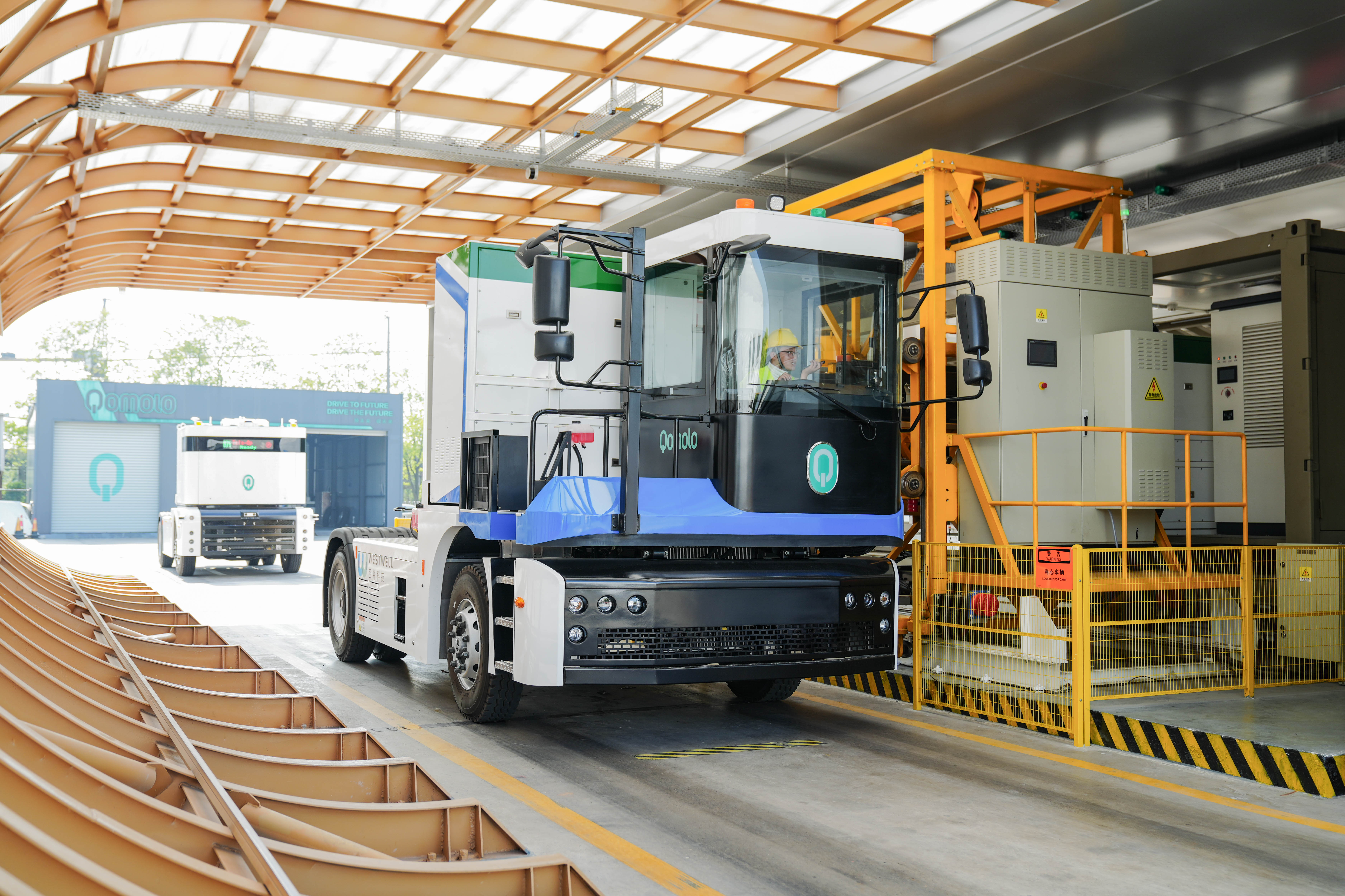 Westwell electric tractor and autonomous terminal tractors executing battery swaps to maintain efficient container transport in port operations.