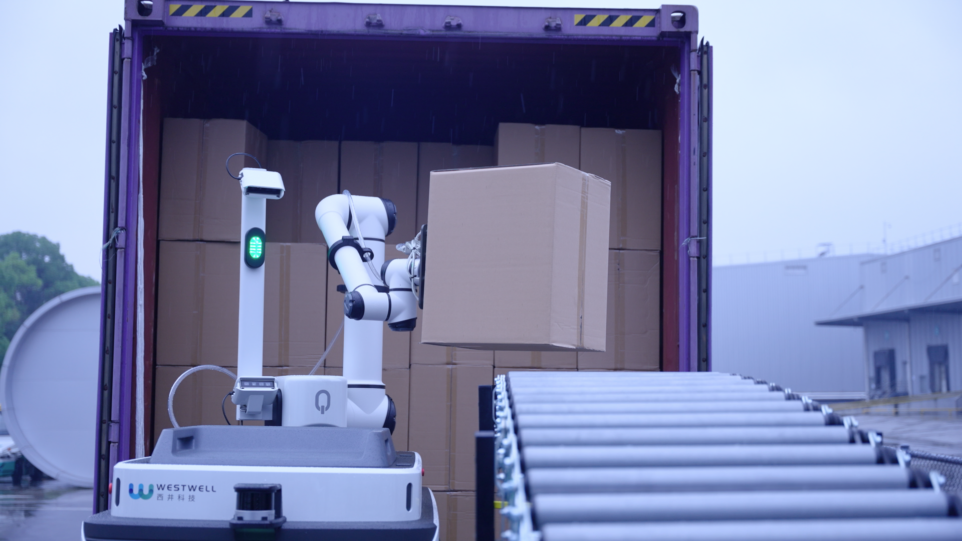 A Well-Bot autonomous mobile robot (AMR) system transferring freight from a truck into a factory logistics area, demonstrating automated material handling and seamless, contactless goods movement between transport vehicles and industrial facilities.