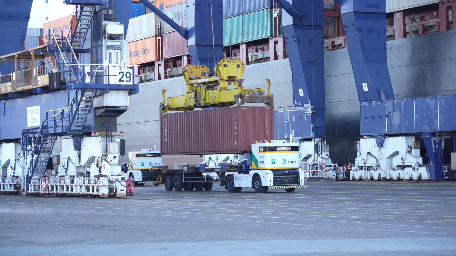 Westwell autonomous truck transporting a container under a quay crane at the Port of Felixstowe